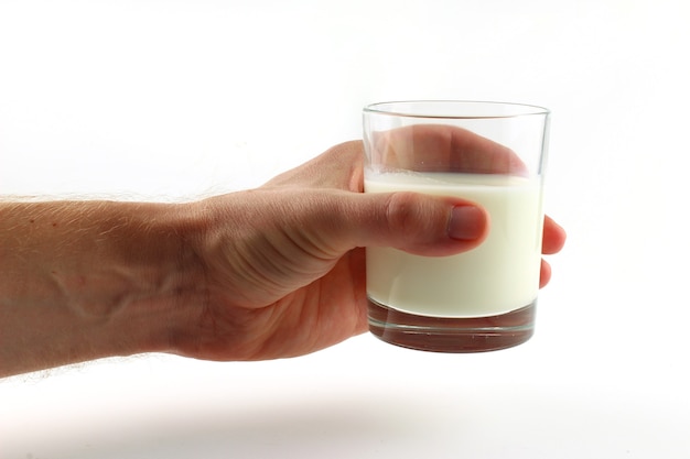 Un verre de lait à la main sur blanc