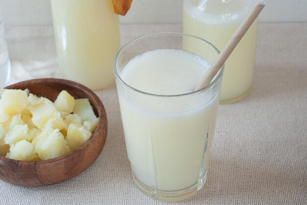 Un verre de lait avec une paille à côté