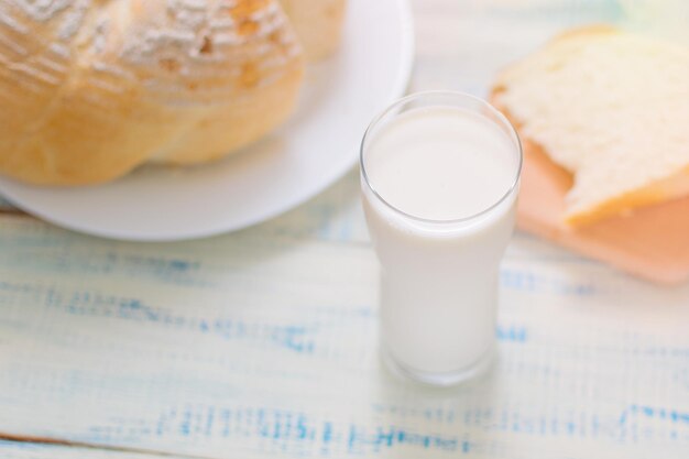 Un verre de lait et de pain blanc sur un fond en bois