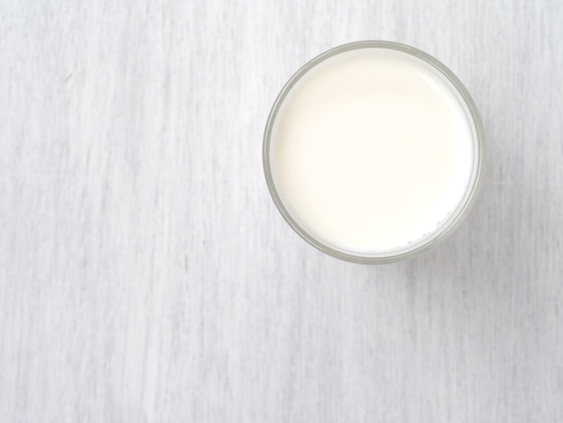 Verre de lait sur un plancher en bois blanc