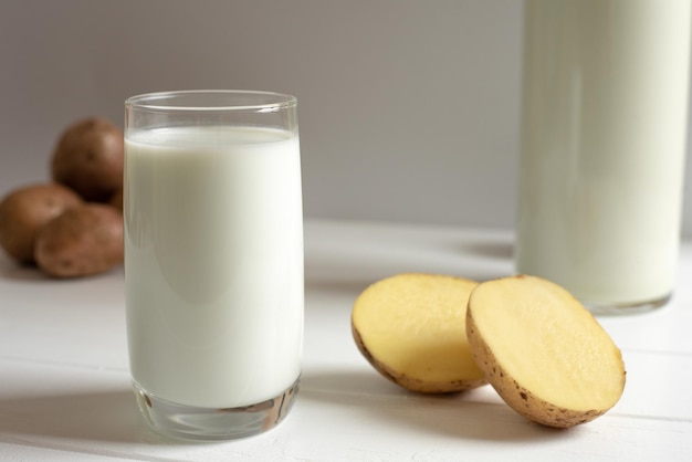 Un verre de lait de pomme de terre sur un fond clair