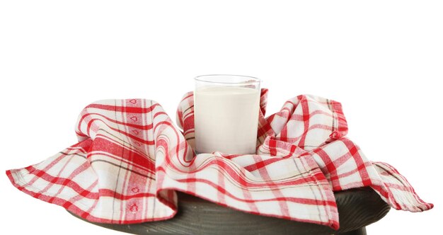 Un verre de lait avec une serviette sur un tabouret en bois isolé sur du blanc