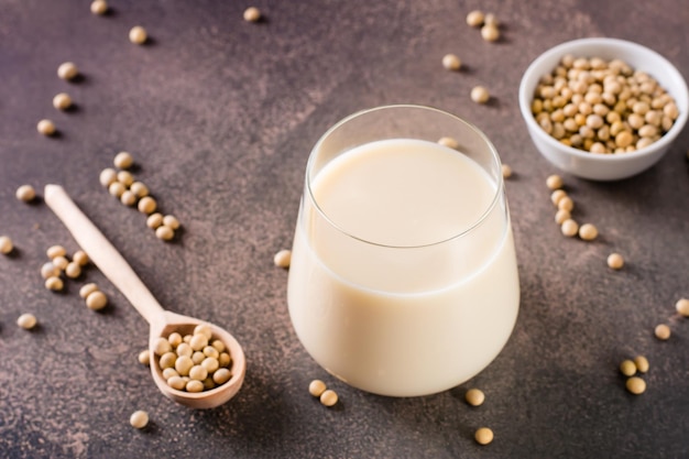 Photo verre de lait de soja et de fèves de soja sur la table protéines végétales