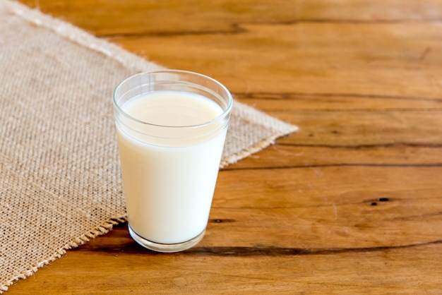 Verre de lait sur table en bois.