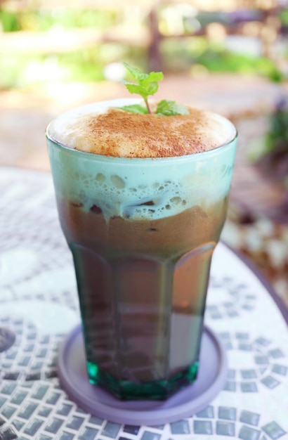 Verre de latte de cacao à la menthe glacée sur la table de jardin