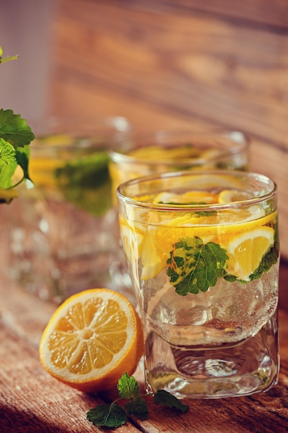 Verre de limonade au citron frais et menthe sur fond en bois