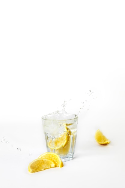 Verre de limonade avec éclaboussures d'eau sur fond blanc avec espace de copie