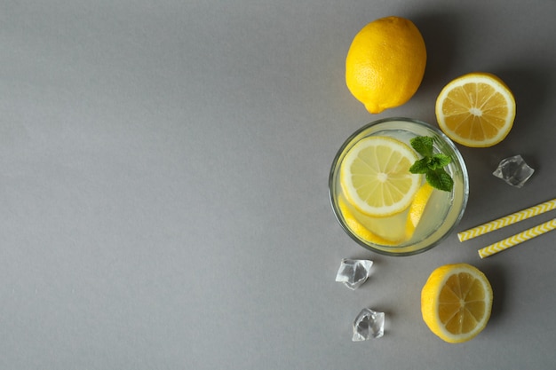 Verre de limonade et ingrédients sur fond gris clair