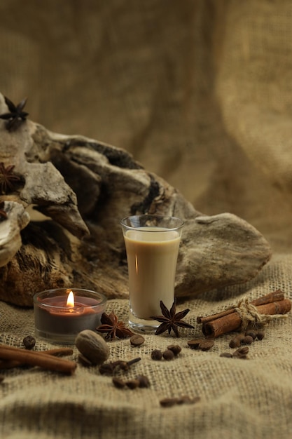 Photo verre de liqueur de crème irlandaise avec fond de tissu d'épices avec espace de copie