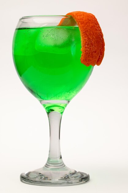 Photo un verre de liqueur vert avec de la glace et de la peau d'orange