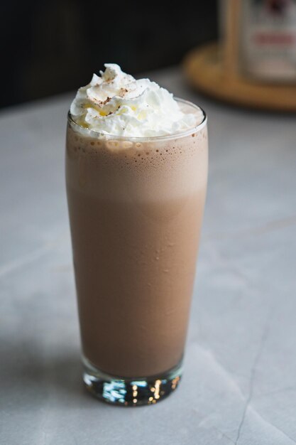 Photo un verre de milkshake au chocolat avec de la crème fouettée sur le dessus.