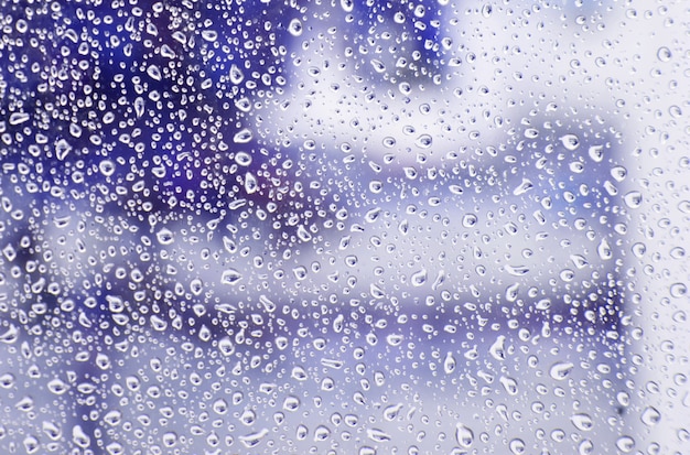 Verre mouillé avec des gouttes de pluie tomber