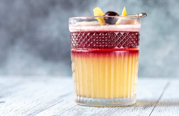 Verre de New York Sour garni de cerise cocktail et de zeste de citron