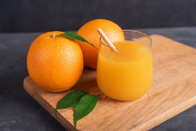 Verre d'orange et de jus et tranche de fruit orange sur un bureau en bois