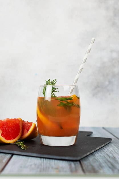 Verre de pamplemousse et romarin gin coctail boisson rafraîchissante sur le fond clair