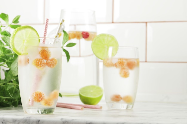 Verre et pichet d'eau douce et de citron vert sur une table en marbre Espace réservé au texte Eau aromatisée Boissons d'été Menthe framboise et citron vert