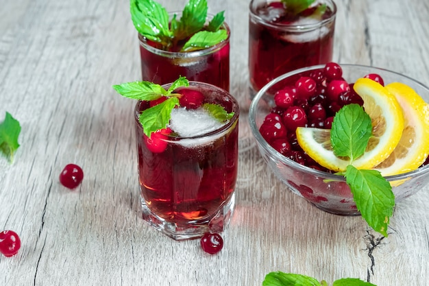 Verre à pied rouge shot cocktail alcoolique froid avec canneberges framboises citron et menthe