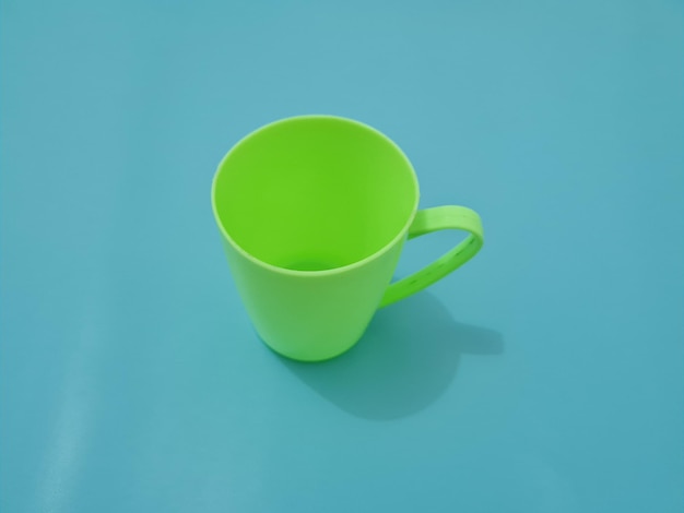 Un verre en plastique avec une poignée verte