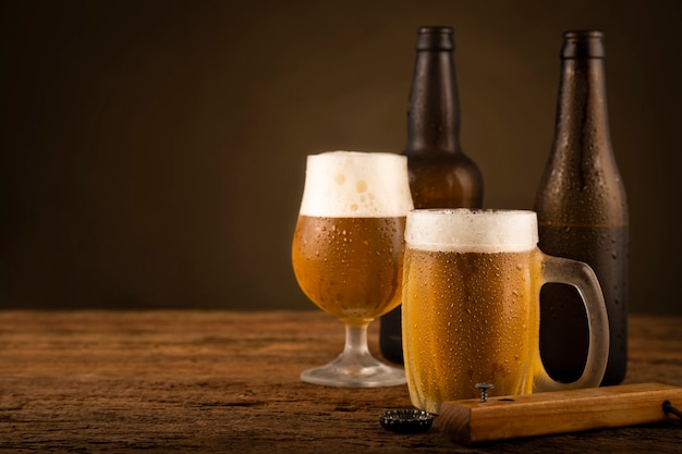 Verre plein de bière froide sur la table en bois