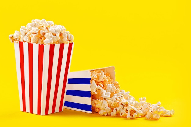 Verre avec pop-corn sur fond jaune