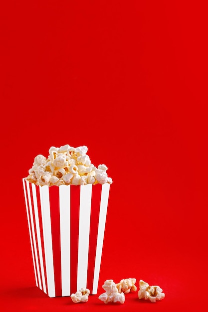 Verre avec pop-corn sur fond rouge