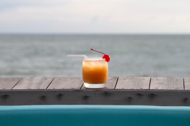 Verre de punch aux fruits avec vue sur l'océan