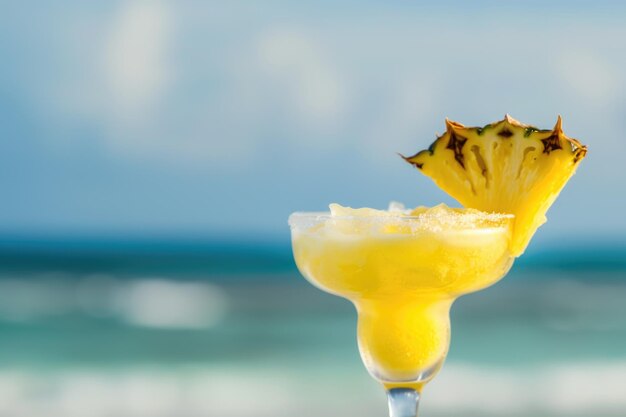 Un verre rempli d'une boisson assis au sommet d'une plage