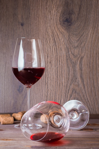 Un verre avec les restes de vin rouge est étendu