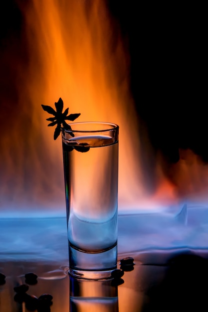 Verre de sambuca en feu avec grains de café et anis étoile