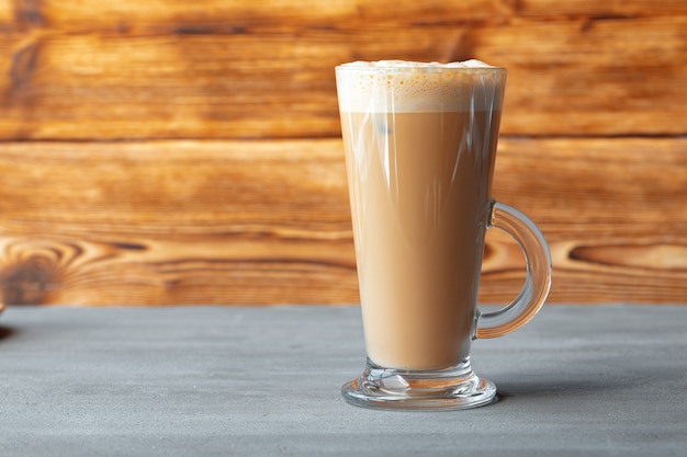 Verre de savoureux latte aromatique sur fond de bois