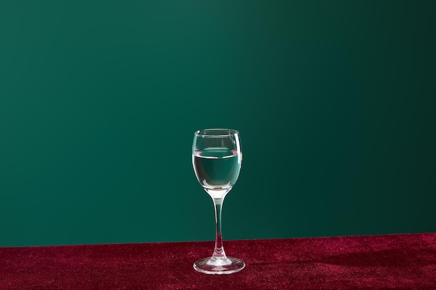 Verre à shot avec liquide transparent pur isolé sur vert