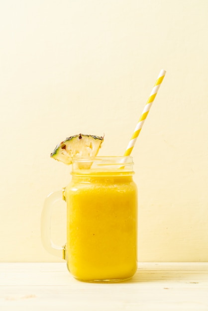 Verre à smoothie ananas frais sur table en bois