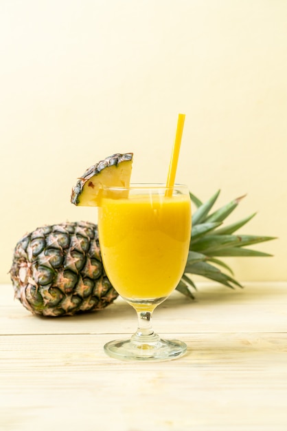 Verre à smoothie ananas frais sur table en bois