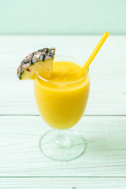 Verre à smoothie ananas frais sur table en bois