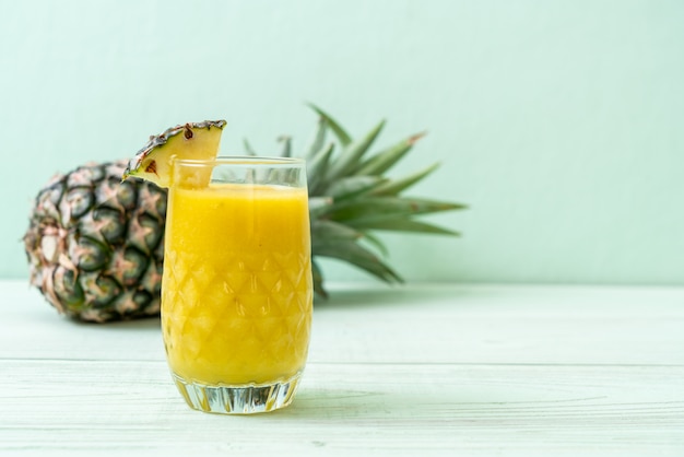 Verre à smoothie ananas frais sur table en bois