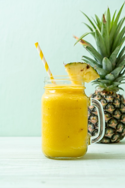 verre à smoothie d'ananas frais sur une table en bois