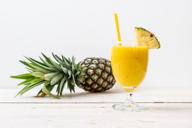 Photo verre à smoothie d'ananas frais sur une table en bois