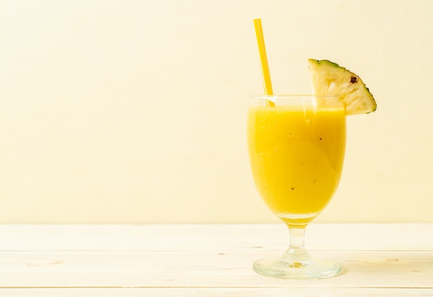 verre à smoothie d'ananas frais sur une table en bois