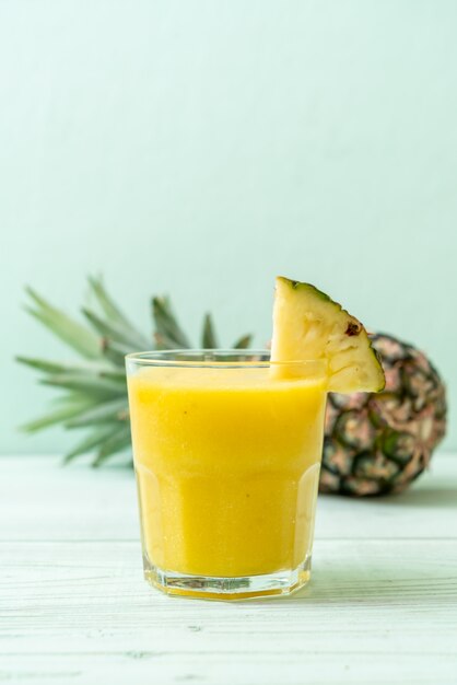 verre à smoothie d'ananas frais sur une table en bois