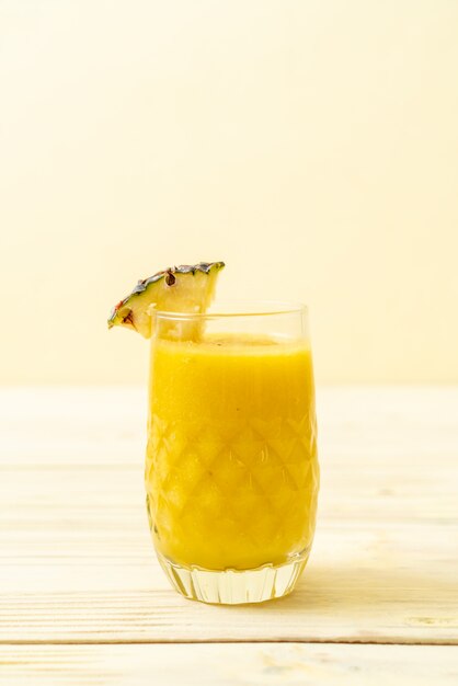 verre à smoothie d'ananas frais sur une table en bois