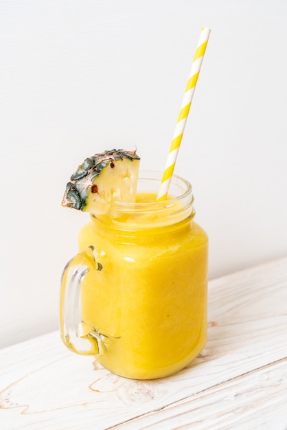 verre à smoothie d'ananas frais sur une table en bois