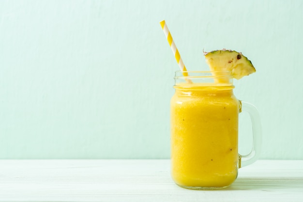 verre à smoothie d'ananas frais sur une table en bois