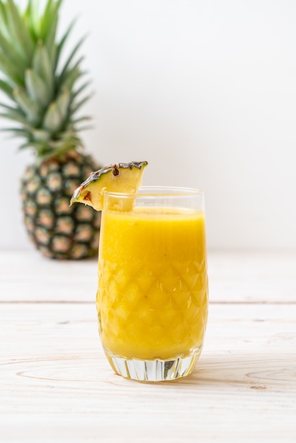 verre à smoothie d'ananas frais sur une table en bois