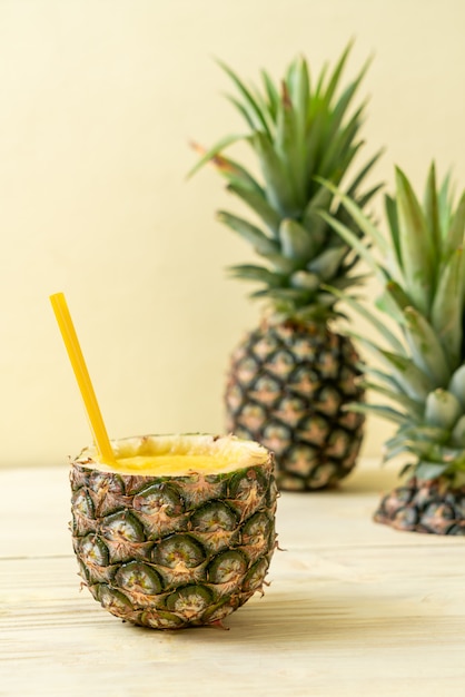 verre à smoothie d'ananas frais sur une table en bois