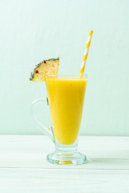 verre à smoothie d'ananas frais sur une table en bois