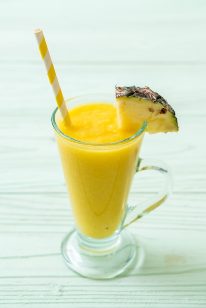 Verre à smoothie ananas frais sur table en bois