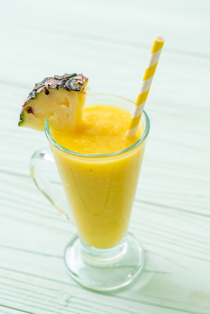 Verre à smoothie ananas frais sur table en bois