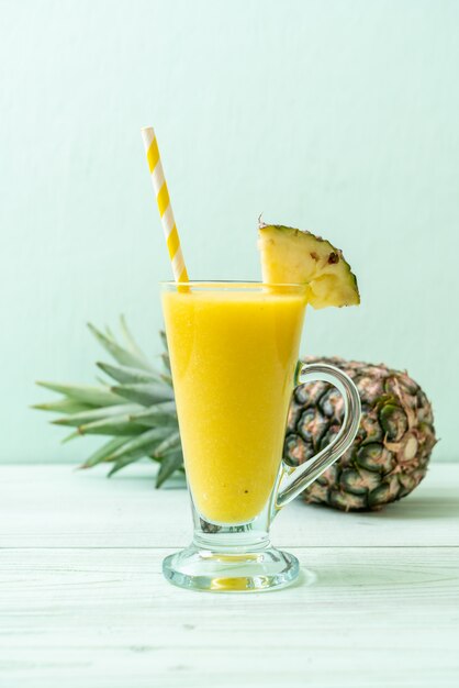 Verre à smoothie ananas frais sur table en bois