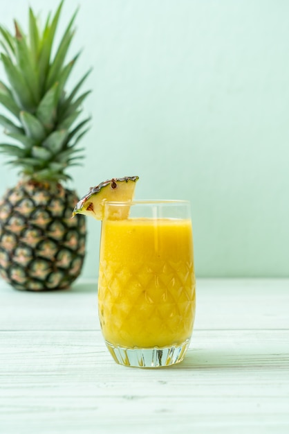 Verre à smoothie ananas frais sur table en bois