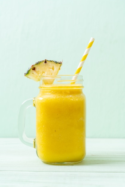 Verre à smoothie ananas frais sur table en bois